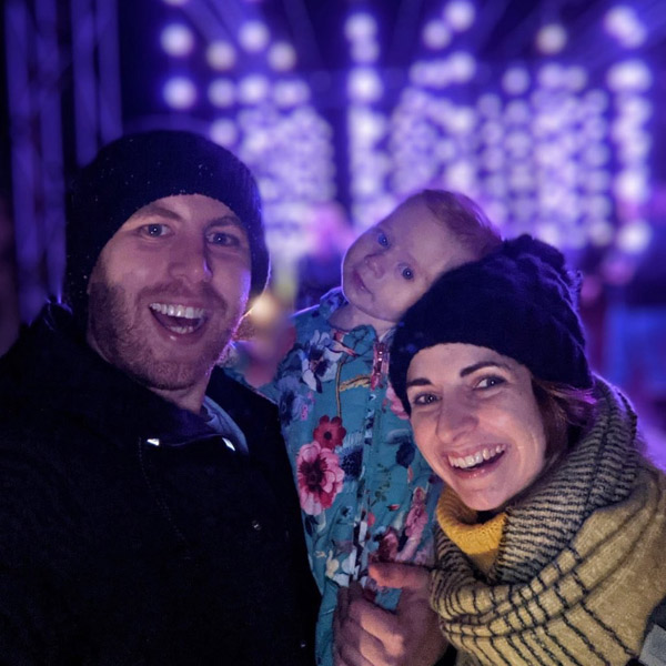 A family selfie in front of glowing lights