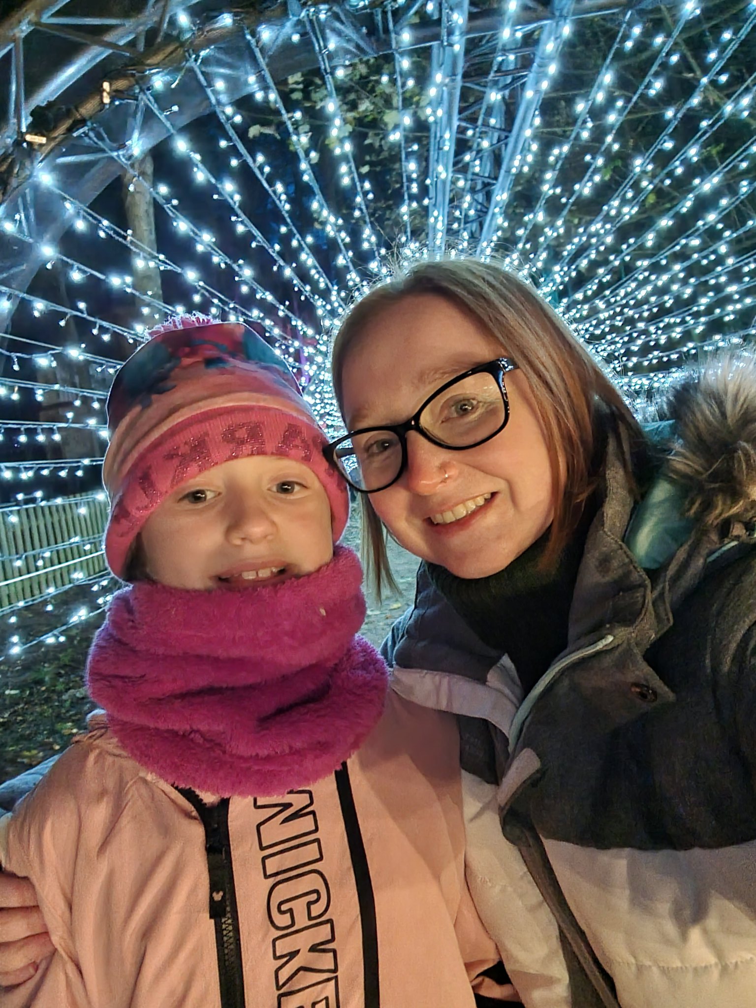 A mother and daughter taking a selfie inside a tunnel of lights